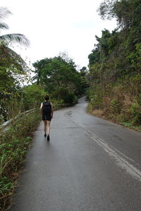 Rear view of woman walking on footpath