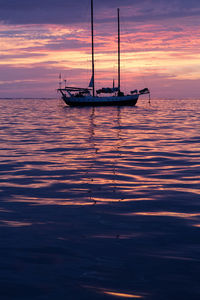 Sailboat in sea at sunset