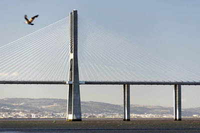 Vasco da gama bridge over tagus river against sky