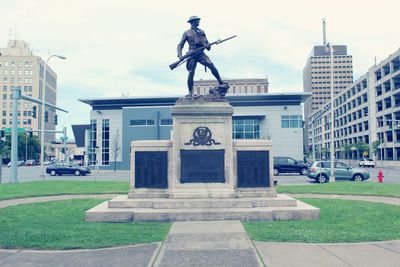 Statue against buildings in city