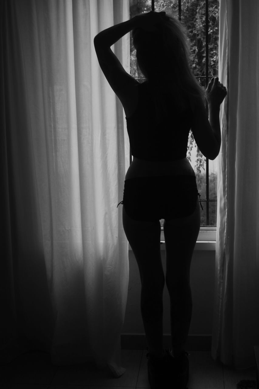 curtain, rear view, one person, standing, indoors, women, adult, window, lifestyles, real people, full length, clothing, home interior, long hair, hairstyle, young adult, females, body part, lingerie, semi-dress