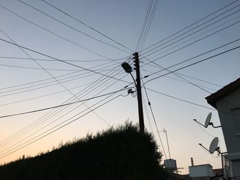 Low angle view of silhouette of electricity pylon against sky