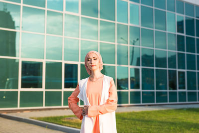 Portrait of woman standing against building