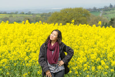 Young woman with yellow flowers in field