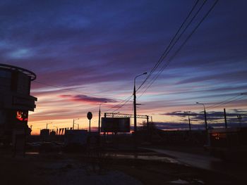 Silhouette electricity pylon against sky during sunset