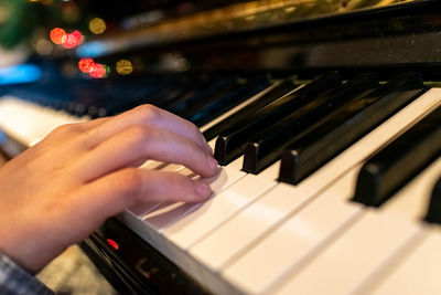 Cropped hand of man playing piano