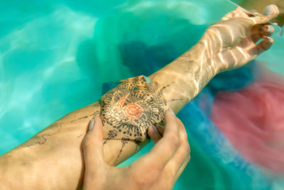 Cropped image of woman with prism on tattoo underwater