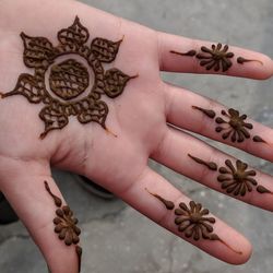 Cropped image of woman with henna tattoo on hand