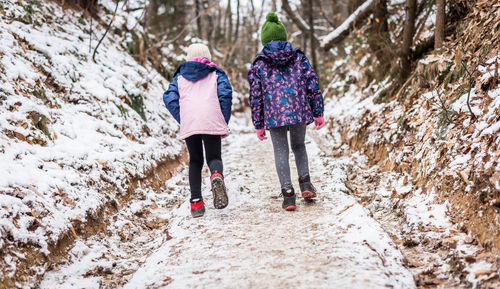 Rear view of women walking in snow