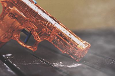 Close-up of wet toy gun on table