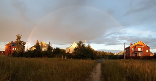 Scenic view of rainbow over field against sky