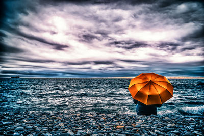 Umbrella on beach against sky