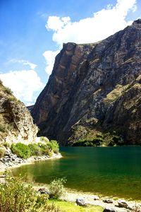 Scenic view of lake by mountain against sky