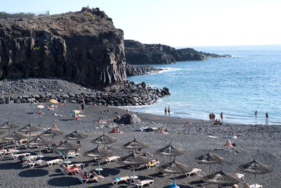 People on beach against clear sky