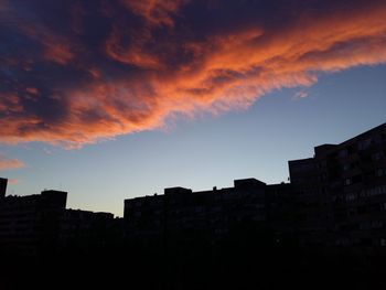 Buildings in city against cloudy sky