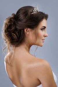 Rear view of beautiful bride against gray background