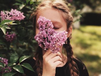 Portrait of woman holding pink flower