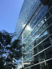 Low angle view of modern building against blue sky