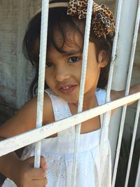 Portrait of smiling girl hanging on metal door