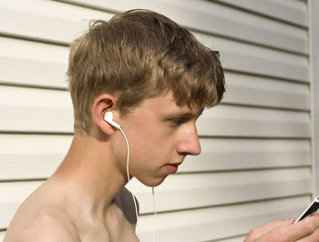 Close-up of teenage boy listening music on mobile phone