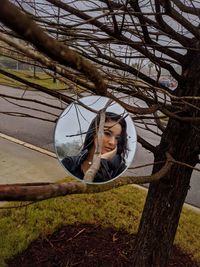 Portrait of woman on tree trunk