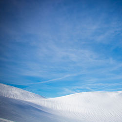 Low angle view of snowcapped mountain against blue sky