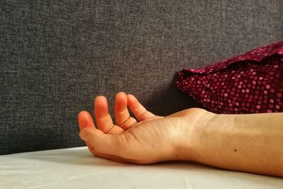 Close-up of hand on red table