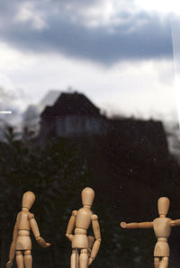 Close-up of figurines by glass window at home