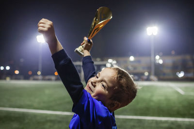 Cute boy holding trophy