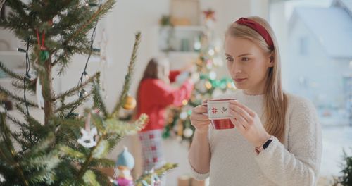 Young woman holding christmas tree