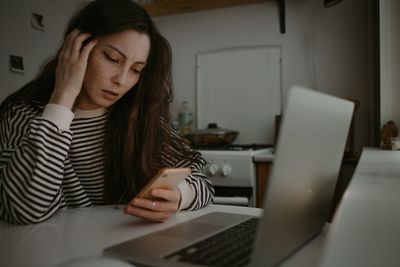 Woman watching on mobile screen with unhappy face reading news