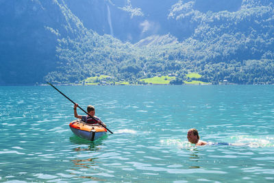 Mother and son kayaking on lake