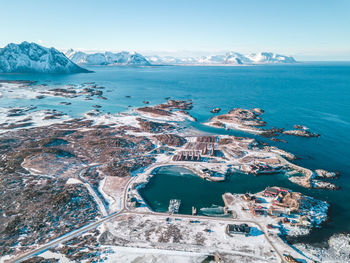 Aerial view of sea and snowcapped mountains against sky