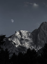 Low angle view of mountain against clear sky at dusk