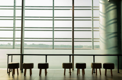 Empty chairs and tables in glass window