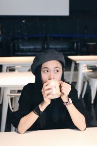 Close-up portrait of a young woman drinking glass