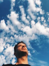 Low angle view of man against cloudy sky