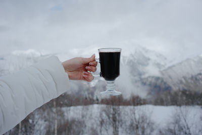 A glass of mulled wine on the top of a mountain in the snow in winter. high quality photo