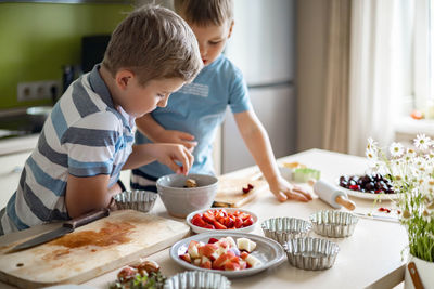 Boys preparing dessert in kitchen