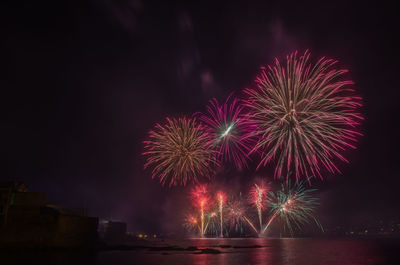 Low angle view of firework display at night