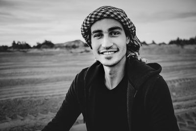 Portrait of smiling young man standing against sky