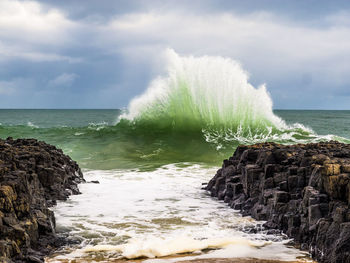 Rocks by sea against sky