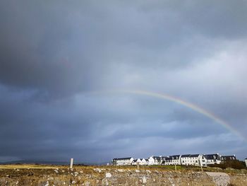 Rainbow over building against sky