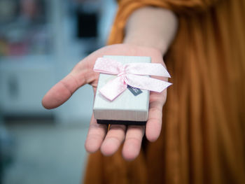 Close-up of woman hand holding gift at table