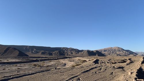 Scenic view of desert against clear blue sky