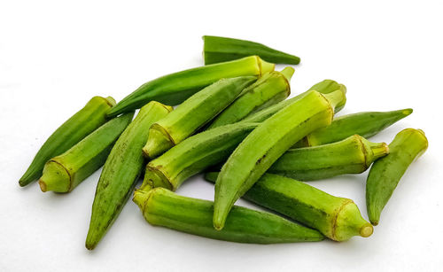 Close-up of green chili pepper against white background