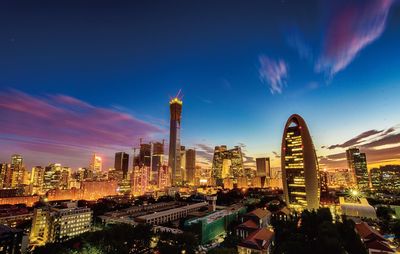 Illuminated cityscape against sky