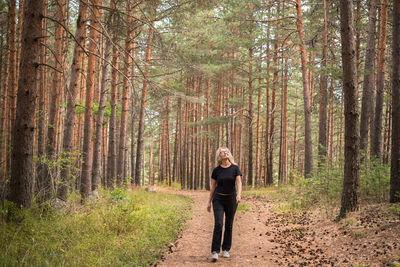 Rear view of woman walking in forest