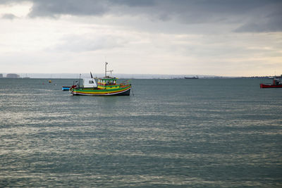 Boat sailing in sea against sky