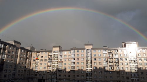 Low angle view of rainbow over buildings in city